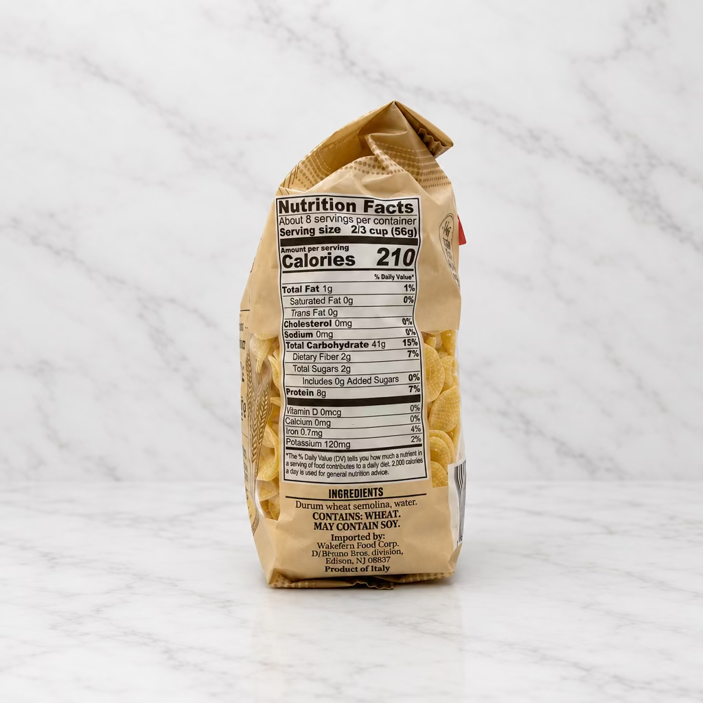 A bag of pasta shown from the back, displaying the nutrition facts label and ingredients, set against a plain white studio background.