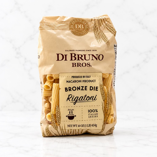 A bag of Di Bruno Bros. Bronze Die Rigatoni macaroni pasta, shown against a plain white studio background.