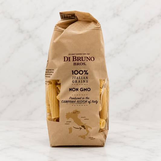 A bag of Di Bruno Bros. 100% Italian Grains Non GMO pasta, shown standing upright on a white studio background.