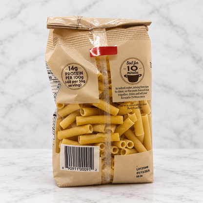 A bag of pasta with a clear window showing the yellow tuberosa pasta inside, set against a plain white studio background.