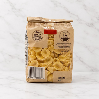 A bag of pasta with visible yellow omelet-shaped pasta pieces through a clear window on a plain white studio background.