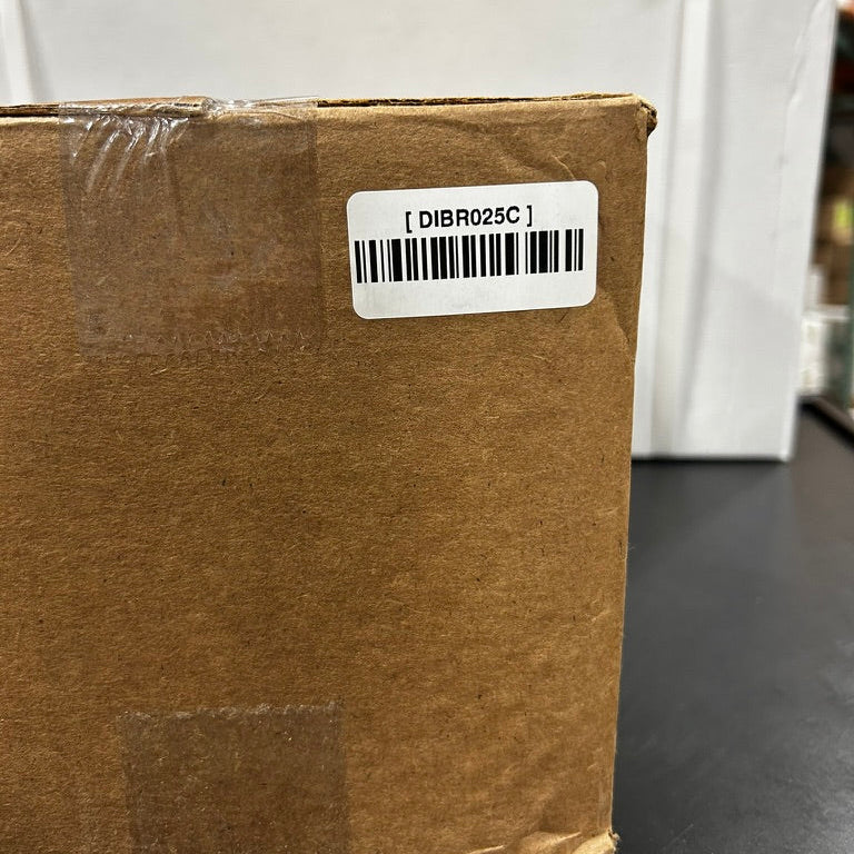 Brown cardboard box with a barcode label on a black surface