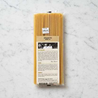 Spaghetti noodles in packaging with a label on a gray background