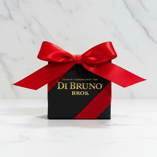 Small black box with a red ribbon featuring 'Di Bruno Bros.' on a gray surface.
