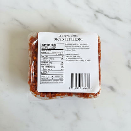 Packaged diced pepperoni with a label on a dark surface
