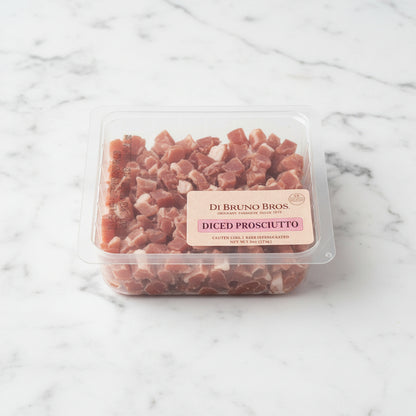 Packaged diced prosciutto on a white surface
