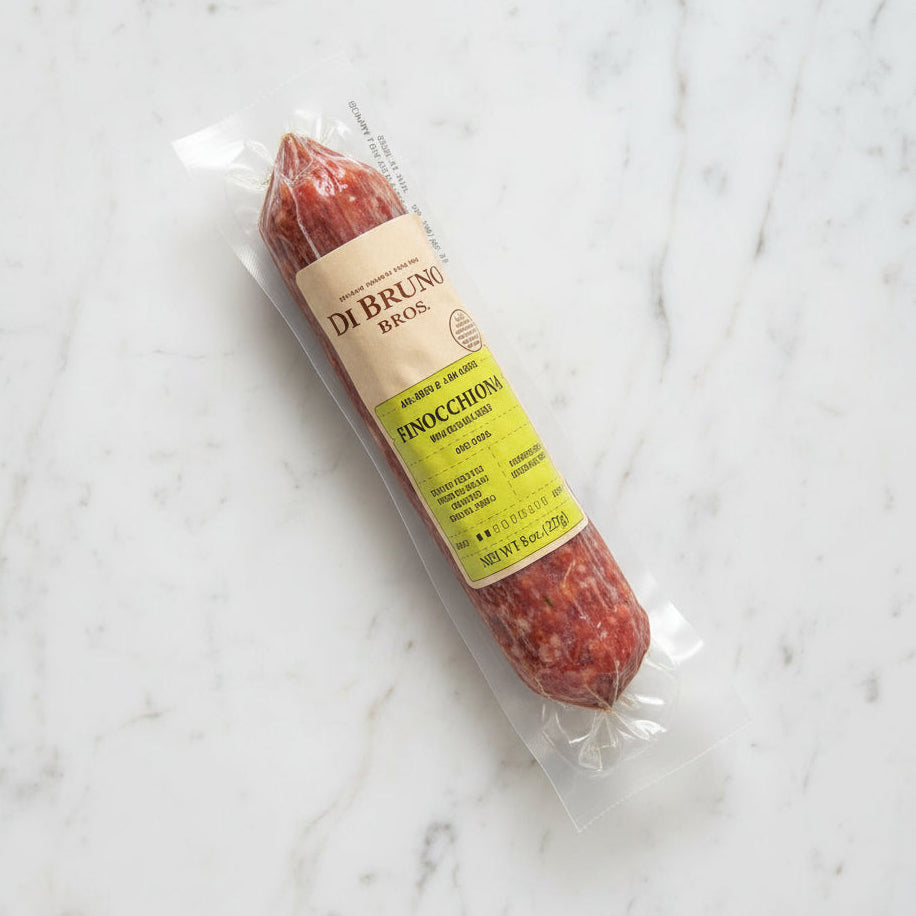 Packaged salami with a label on a dark surface