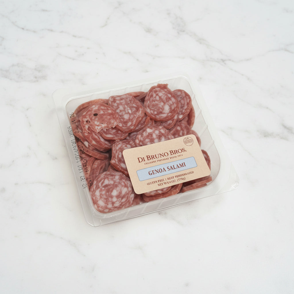 Packaged salami on a white surface with a brown background