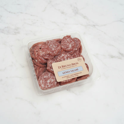 Packaged salami on a white surface with a brown background