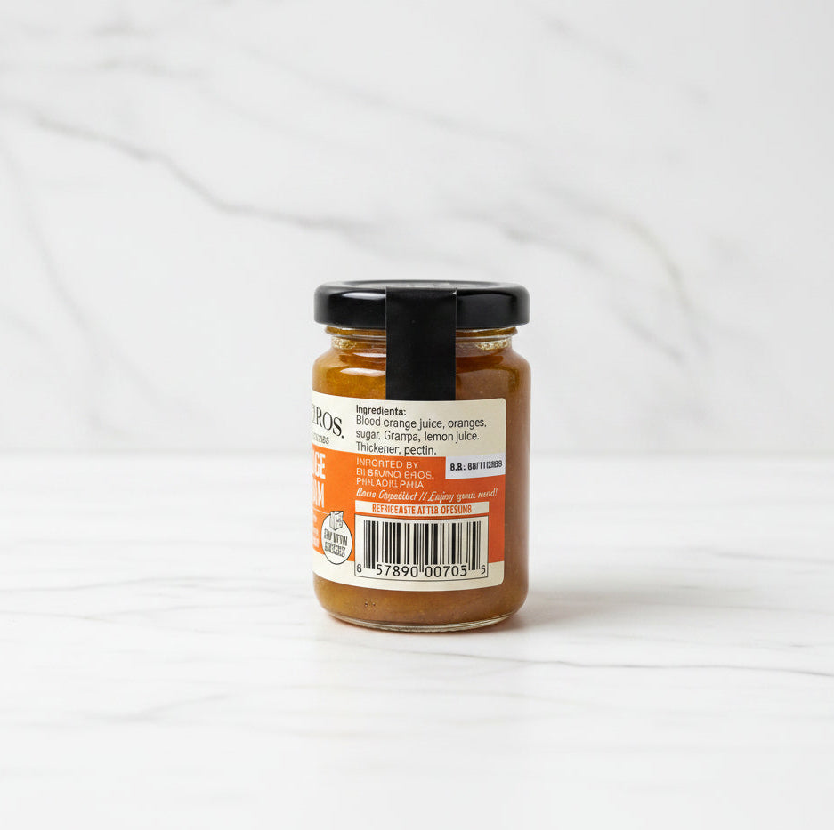 Small jar of jam with a label on a black surface