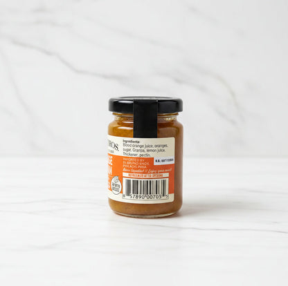 Small jar of jam with a label on a black surface