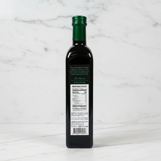 Bottle of olive oil with a nutrition label on a reflective surface