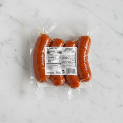 Four sausages in a clear plastic package on a black background