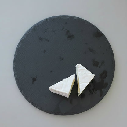 Two triangles of white cheese  on a dark slate surface