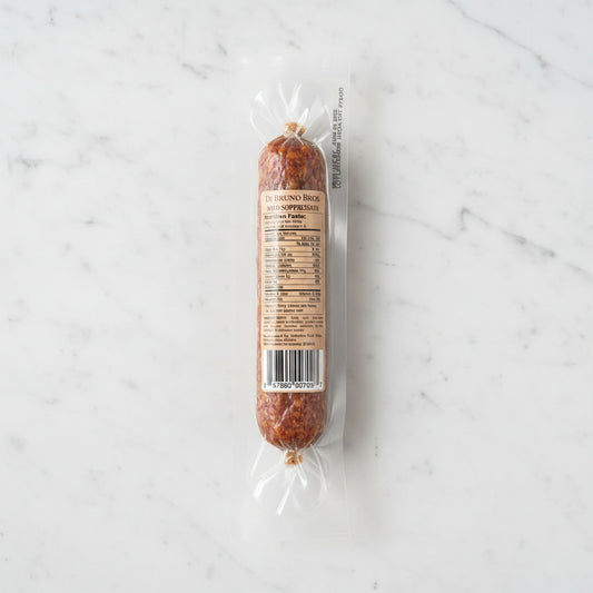 Packaged salami with a label on a dark surface