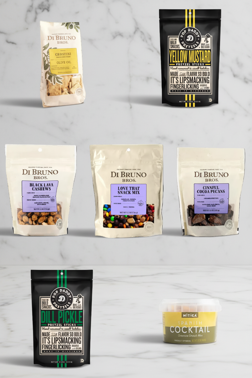 Collection of Di Bruno Bros. snack mixes and a cocktail on a marble surface