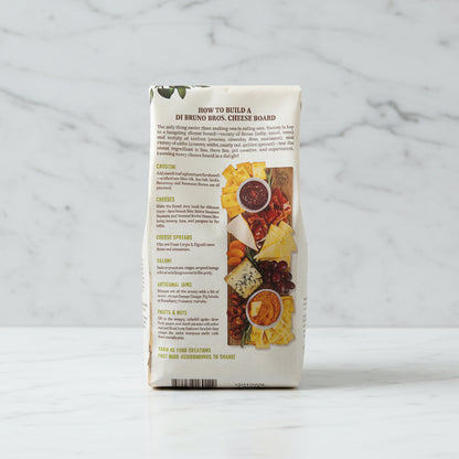 Di Bruno Bros. cheese board packaging with text and images of cheese and fruits.
