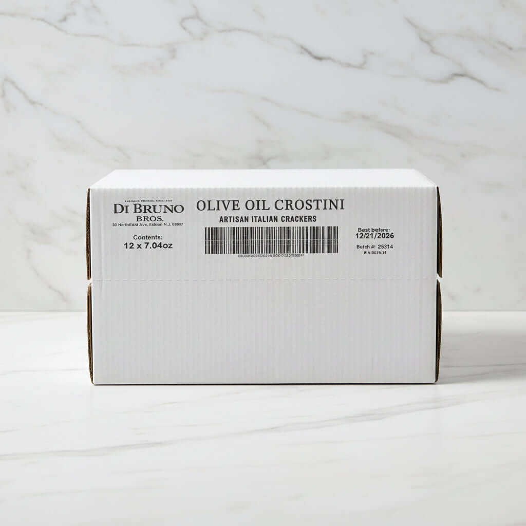 Stack of Di Bruno Bros. olive oil crostini boxes in a warehouse setting