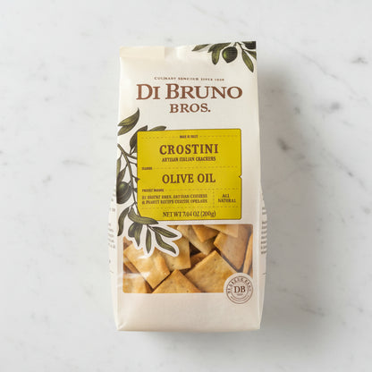 Di Bruno Bros Crostini Olive Oil package on a dark surface with a neutral background