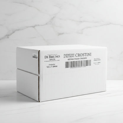 Stack of white boxes with Di Bruno Bros. branding on a conveyor belt in a warehouse.