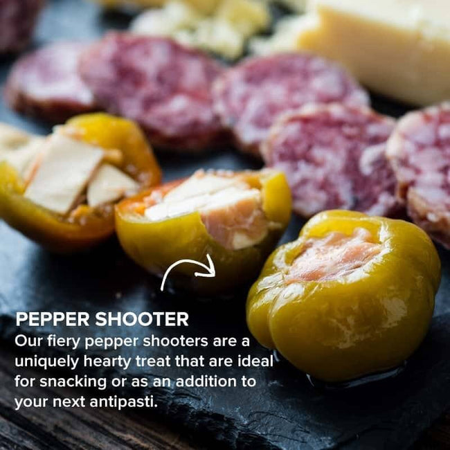 Close-up of Di Bruno Bros. stuffed pepper shooters served beside sliced cured meat