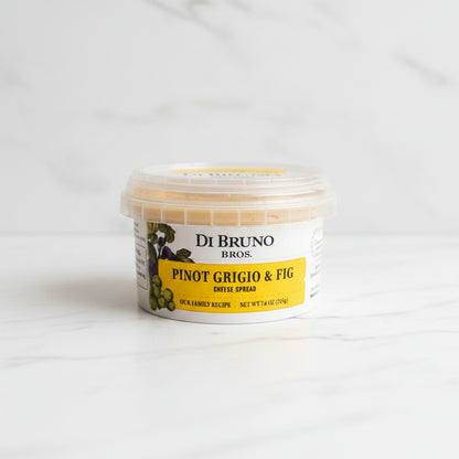 Container of Di Bruno Bros. Pinot Grigio & Fig cheese spread on a dark surface with a white background.