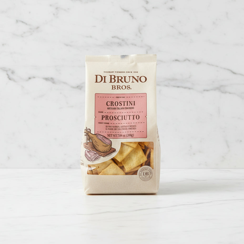 Package of Di Bruno Bros Crostini Prosciutto on a dark surface with a blurred background
