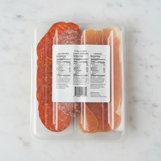 Packaged deli meats including salami and prosciutto on a black surface