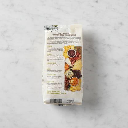 Package of Di Bruno Bros. Cheese Board with text and images on a dark surface