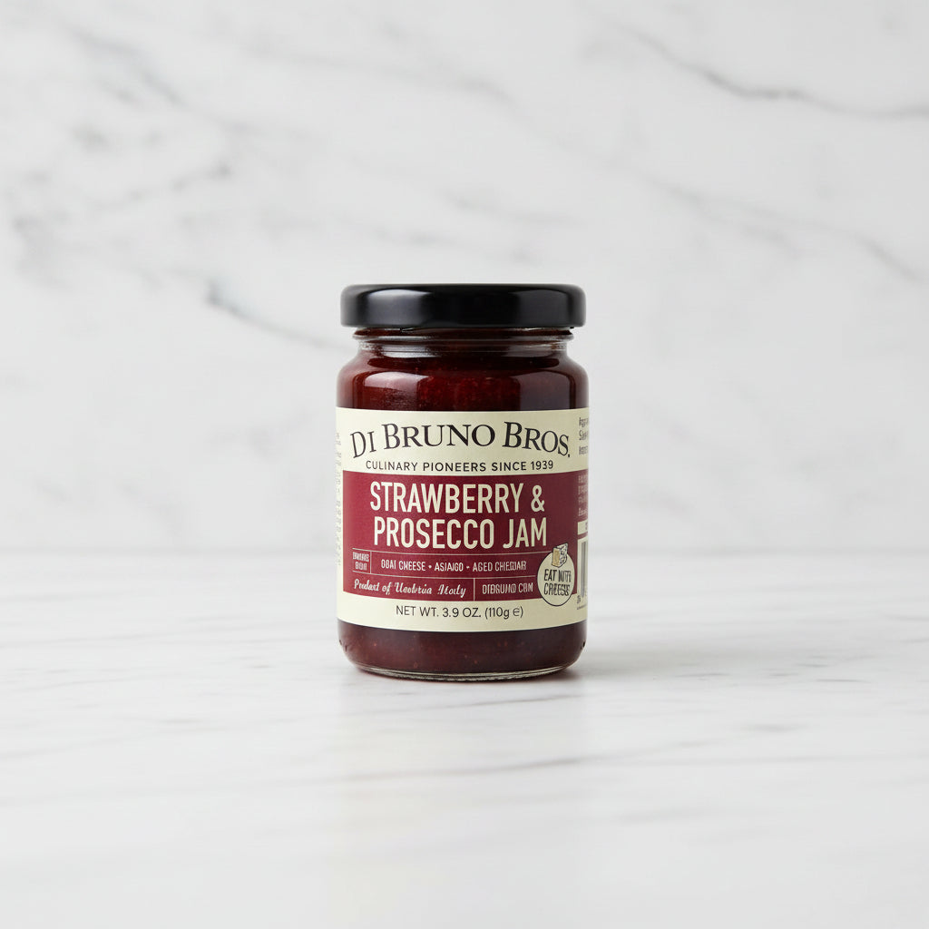 Jar of strawberry and prosecco jam on a black surface with a white background