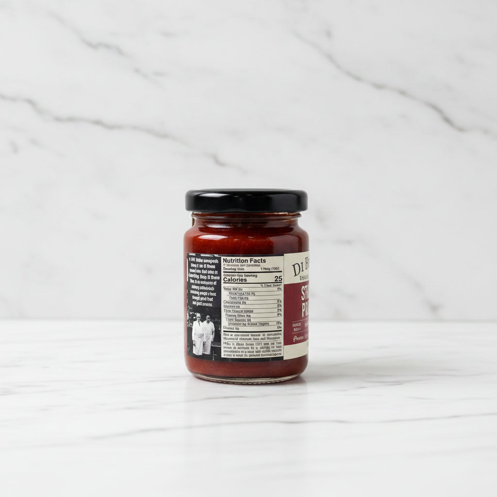 Jar of sauce with a label on a white marble surface