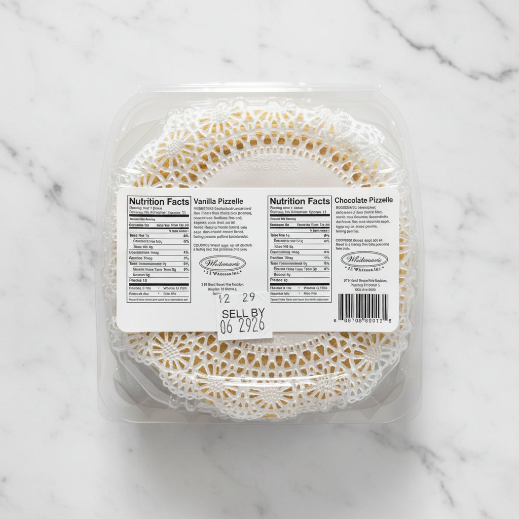 Packaged vanilla and chocolate pizzelles with nutrition labels on a dark surface.