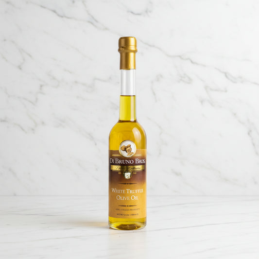Bottle of Dr. Bruno Bros White Truffle Olive Oil on a black surface with a white background