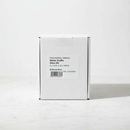 Box of White Truffle Olive Oil on a dark surface with a light gray background