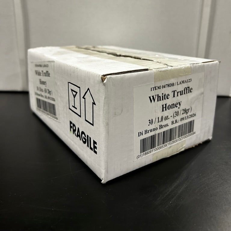 Box of White Truffle Honey with fragile label on a black surface