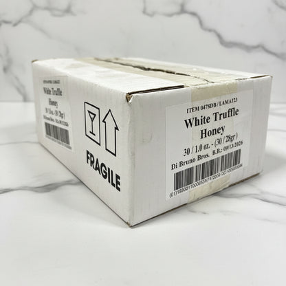 Box of White Truffle Honey with fragile label on a black surface