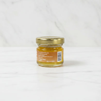 Small jar with a gold lid on a dark surface