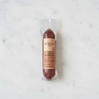 Spicy sausage link with a label on a marble surface