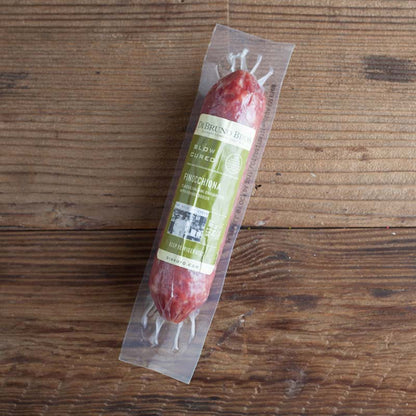 Packaged Finocchiona Salami displayed on a wooden surface.