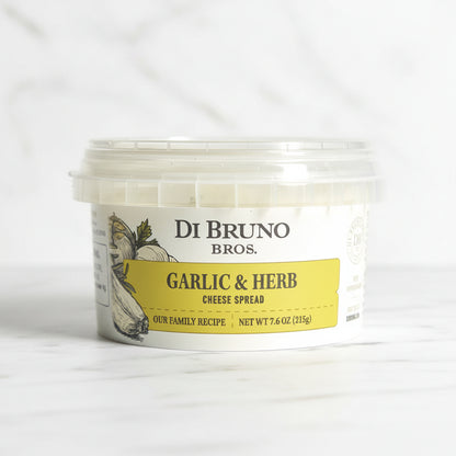 A tub of Di Bruno Bros. Garlic & Herb Cheese Spread on a white background.