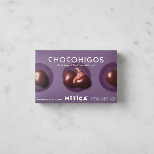 A rectangular box of Chocohigos hand-dipped dark chocolate figs by Mitica, featuring a purple background with four
chocolate-covered figs and the brand name clearly visible.