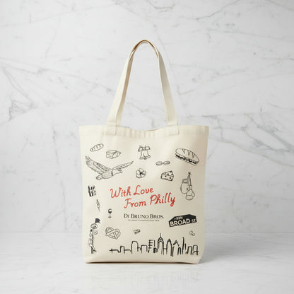 Tote bag with Philadelphia-themed graphics and text on a wooden surface