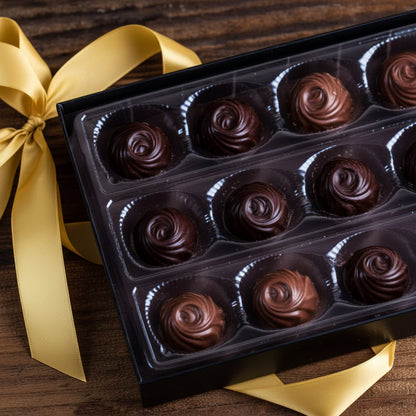 Box of chocolate roses with a red ribbon on a wooden surface